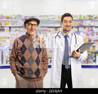 Chimiste et un homme âgé debout dans une pharmacie et regardant la caméra Banque D'Images