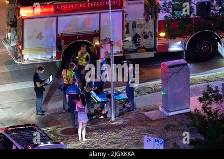 Austin Texas USA, juillet 2022 : des membres du service d'incendie d'Austin et du service de police d'Austin réagissent à un accident au coin de 12th et au centre-ville de Guadalupe où un homme a été transporté à l'hôpital avec des blessures. Les circonstances de l'accident sont inconnues. ©Bob Daemmrich Banque D'Images