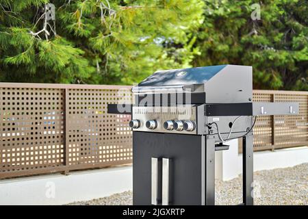 Barbecue à gaz en acier inoxydable dans l'arrière-cour de la maison privée. Cuisiner de la viande, du poisson, des légumes dans les rassemblements d'été, pas de personnes Banque D'Images