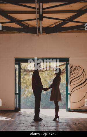 silhouette de couple debout tenant les mains Banque D'Images