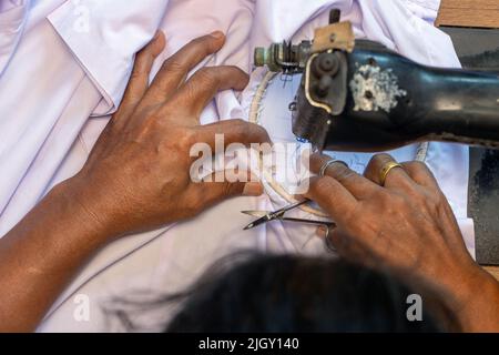 Broder des numéros thaïlandais sur une chemise d'étudiant sur une vieille machine à coudre Banque D'Images