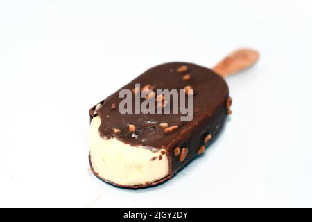 Crème glacée riche à la vanille, au chocolat au lait brun craquant et à l'amande rôtie, isolée sur fond blanc, crème glacée à la vanille recouverte d'un bâton et d'un c Banque D'Images