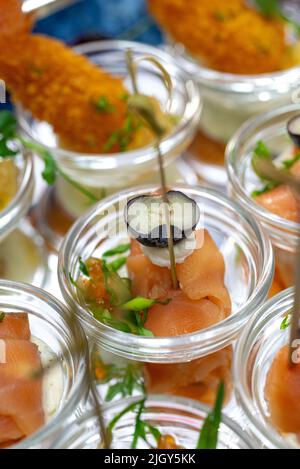 rouleaux de saumon avec olive et caviar dans un récipient en verre. Banque D'Images