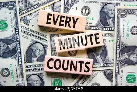 Chaque minute compte le symbole. Concept mots chaque minute compte sur des blocs de bois sur un beau fond de billets de dollar. Entreprise, motivation et Banque D'Images
