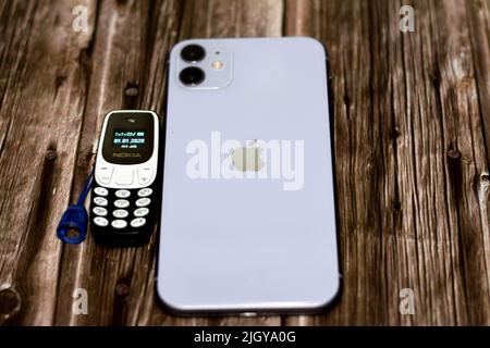 Le Caire, l'Egypte, 11 juin 2022: Apple iPhone 11 avec 6,1inch liquide Retina HD haute définition écran et un petit vieux mini téléphone cellulaire Nokia avec un ke Banque D'Images