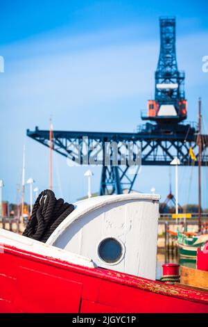 Partie de l'ancien chalutier en bois avec hublot de cabine et construction de grue en acier au fond du ciel (espace de copie) Banque D'Images