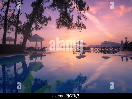 Belle réflexion dans la piscine au coucher du soleil coloré Banque D'Images