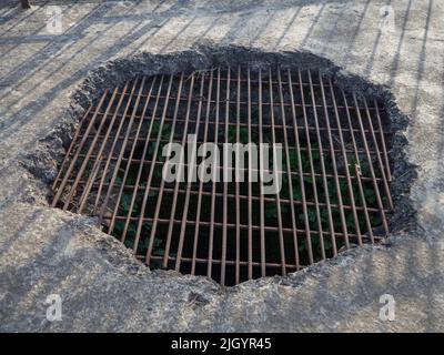 Un trou dans le sol en béton recouvert de caillebotis. Piège. Cellule dans le donjon. Banque D'Images