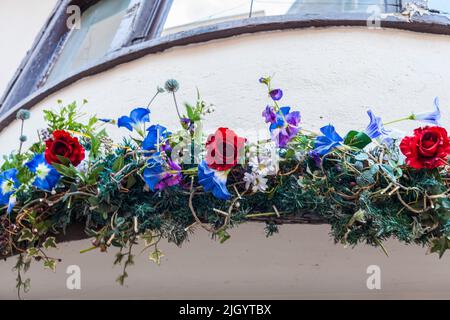 Une rangée de fleurs y compris des roses décorant la baie d'un magasin à York, North Yorkshire, Angleterre, Royaume-Uni Banque D'Images