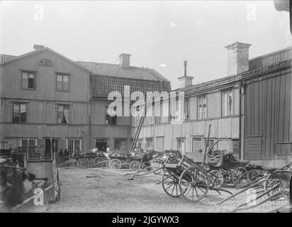 Intérieur de la ferme, Svartbäcksgatan 23, quartier de Hjorten, Dragarbrunn, Uppsala 1908. Svartbäcksgatan 23 dans le bloc Hjorten. Une ferme commerciale caractéristique dont les bâtiments proviennent principalement du 1820s. La ferme était l'un des nombreux quartiers fermiers le long de Svartbäcksgatan. La cour servait de stand aux chevaux et aux cavaliers des clients. Pendant les marchés, vous pourriez à la fois compter jusqu'à 80 chevaux et 20 agriculteurs qui ont passé la nuit dans les soi-disant Bodkamers de la ferme. 'D'Ola Ehn & Gunnar Elfström, le tournant du siècle Uppsala dans les images de Dahlgren. Nature et culture 1977. Banque D'Images