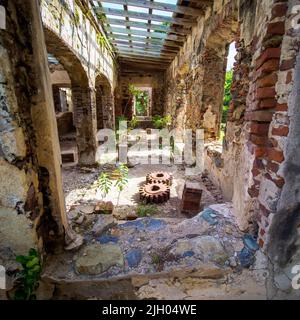 Bâtiment en pierre abandonné avec toit ouvert et fûts machine sur le sol dans les îles Vierges Banque D'Images