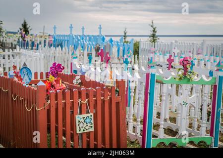 Tombes colorées en bois clôturées dans un cimetière en été, dans la communauté indigène du nord de Deline, Territoires du Nord-Ouest, Canada Banque D'Images