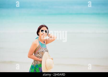 Femme asiatique d'âge moyen se détendant à la plage de chaweng à koh samui, en Thaïlande. Banque D'Images