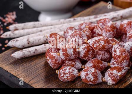 Tranches de saucisse de Fuet espagnol, sur fond de béton foncé Banque D'Images