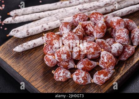 Tranches de saucisse de Fuet espagnol, sur fond de béton foncé Banque D'Images