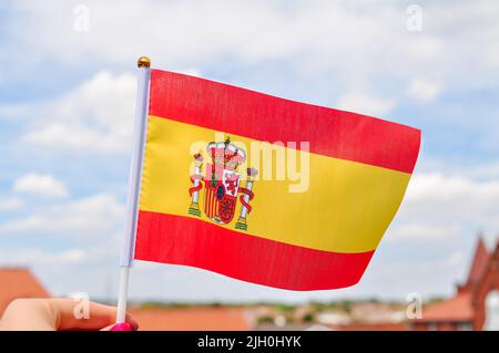 Gros plan du drapeau national espagnol jaune et rouge, drapeau de la main. Banque D'Images