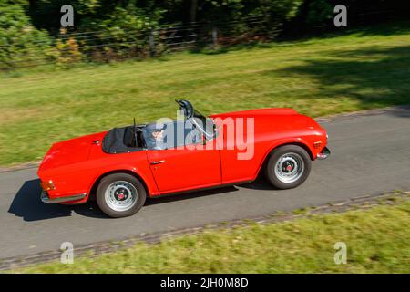 Classique rouge vintage 1970s triomphe TR6 voiture de sport panoramique tourné sur la route Banque D'Images