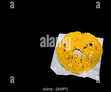 Dessert indien traditionnel - Ghewar ou Ghevar est un rajasthani, Punjabi doux crémeux. Fabriqué sur Teej,Raksha Bandhan,Janmashtami.Top View,fond noir. Banque D'Images