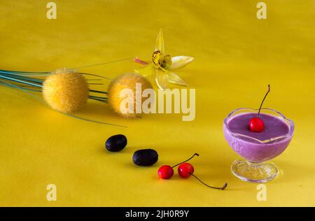 Jamun Mousse, Malabar Plum mousse aux fruits avec garniture de cerise. Dessert frais fait maison à partir de Jamun. Pudding d'été sur fond jaune foncé, en gros plan. Banque D'Images