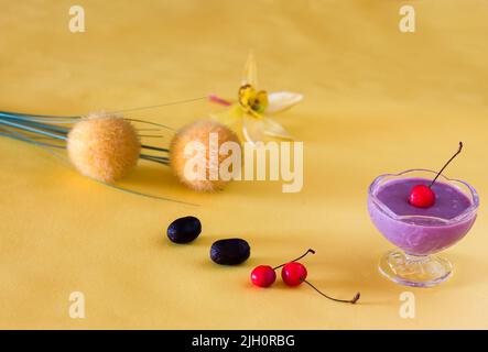 Jamun Mousse, Malabar Plum mousse aux fruits avec garniture de cerise. Dessert frais fait maison à partir de Jamun. Pudding d'été sur fond jaune foncé, en gros plan. Banque D'Images