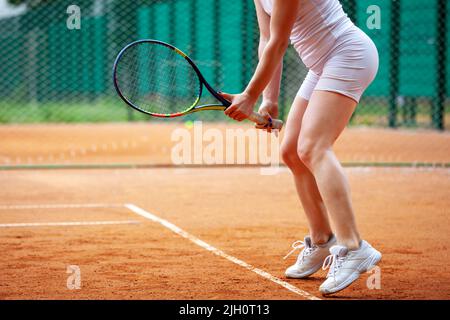 Section médiane d'une joueuse de tennis féminine tenant la raquette en position de repos. Banque D'Images