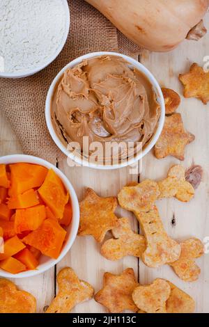 biscuits biologiques faits maison pour chiens et ingrédients sur bois brut avec espace de copie Banque D'Images