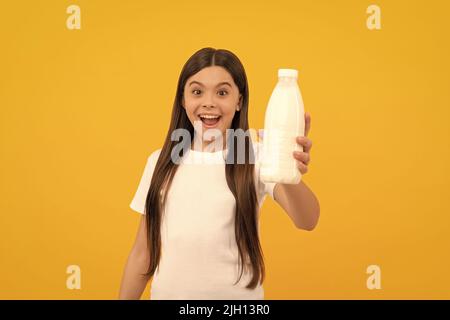 l'enfant émerveillé offre des produits de boisson laitière. jeune fille va boire du lait. Banque D'Images