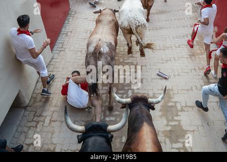 Pampelune, Espagne. 14th juillet 2022. Un coureur tombe au sol comme plusieurs taureaux et haltes passent lors de la dernière course de taureaux des festivités de San Fermin 2022 à Pampelune. Crédit : SOPA Images Limited/Alamy Live News Banque D'Images