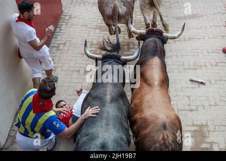 Pampelune, Espagne. 14th juillet 2022. Un coureur tombe au sol comme plusieurs taureaux et haltes passent lors de la dernière course de taureaux des festivités de San Fermin 2022 à Pampelune. Crédit : SOPA Images Limited/Alamy Live News Banque D'Images