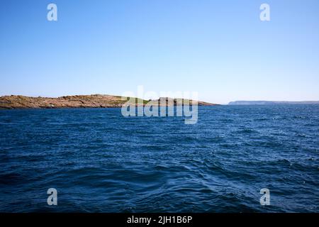 île winkle grande île de skerry en mer au large des îles de skerries avec l'île de rathlin en arrière-plan sur la côte nord de l'irlande pendant un été plus ou plus Banque D'Images