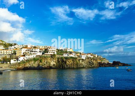 Camara de Lobos, Madère, Portugal - 4 décembre 2019 : maisons et bâtiments le long de la baie portuaire du village de pêcheurs populaire au coucher du soleil. Banque D'Images