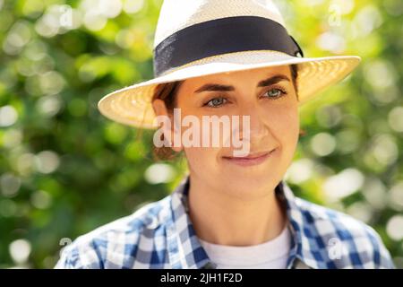 portrait d'une femme en chapeau de paille dans le jardin d'été Banque D'Images