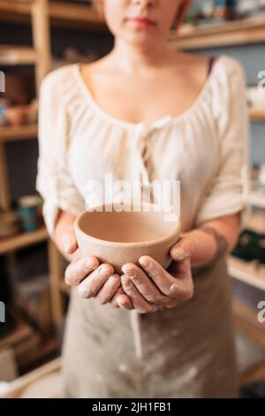 Femme méconnaissable tenant un bol vide, vide. Photo de la personne industrieuse, montrant son résultat de travail. Idée de publicité agricole Banque D'Images