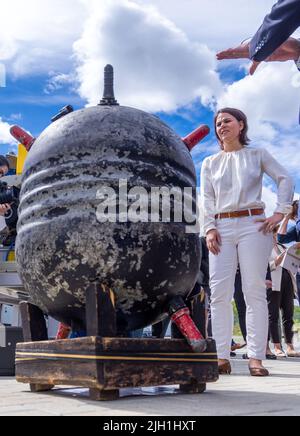 Rostock, Allemagne. 14th juillet 2022. Annalena Baerbock (Bündnis 90/Die Grünen), ministre des Affaires étrangères, se tient derrière une mine d'eau (mine de mer) de la première Guerre mondiale récupérée en mer du Nord lors de sa visite à l'Institut Fraunhofer de recherche en infographie au début de son voyage de dix jours en Allemagne. Au cours de sa tournée, la politicienne verte veut recueillir des renseignements et des impressions pour une stratégie de sécurité nationale. L'institut mène des recherches sur les effets écologiques des déchets de munitions et sur la détection des munitions dans la mer. Credit: Jens Büttner/dpa/Alay Live News Banque D'Images