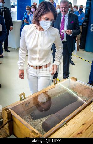 Rostock, Allemagne. 14th juillet 2022. Annalena Baerbock (Bündnis 90/Die Grünen), ministre des Affaires étrangères, regarde une boîte de munitions provenant de la mer Baltique lors de sa visite à l'Institut Fraunhofer de recherche en infographie au début de son voyage de dix jours en Allemagne. Au cours de sa tournée, la politicienne verte veut recueillir des renseignements et des impressions pour une stratégie de sécurité nationale. L'institut mène des recherches sur les effets écologiques des déchets de munitions et sur la détection des munitions dans la mer. Credit: Jens Büttner/dpa/Alay Live News Banque D'Images