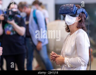 Rostock, Allemagne. 14th juillet 2022. Annalena Baerbock (Bündnis 90/Die Grünen), ministre des Affaires étrangères, regarde les lunettes de réalité virtuelle lors de sa visite à l'Institut Fraunhofer de recherche en infographie au début de son voyage de dix jours en Allemagne. La politicienne verte veut recueillir des informations et des impressions pour une stratégie de sécurité nationale au cours de sa tournée. L'institut mène des recherches sur l'impact écologique des déchets de munitions et sur la détection des munitions en mer. Credit: Jens Büttner/dpa/Alay Live News Banque D'Images