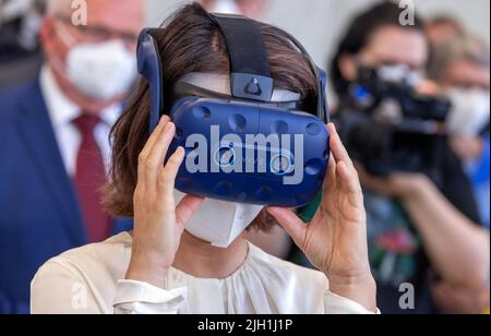 Rostock, Allemagne. 14th juillet 2022. Annalena Baerbock (Bündnis 90/Die Grünen), ministre des Affaires étrangères, regarde les lunettes de réalité virtuelle lors de sa visite à l'Institut Fraunhofer de recherche en infographie au début de son voyage de dix jours en Allemagne. La politicienne verte veut recueillir des informations et des impressions pour une stratégie de sécurité nationale au cours de sa tournée. L'institut mène des recherches sur l'impact écologique des déchets de munitions et sur la détection des munitions en mer. Credit: Jens Büttner/dpa/Alay Live News Banque D'Images