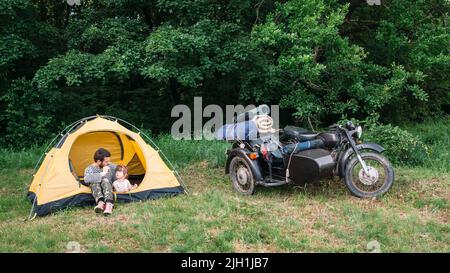 Le père et la fille voyagent en moto pour camper Banque D'Images