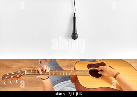 homme avec microphone sur table jouant de la guitare Banque D'Images