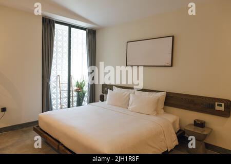 Vue panoramique d'une belle chambre d'hôtel élégante avec lit au centre Banque D'Images