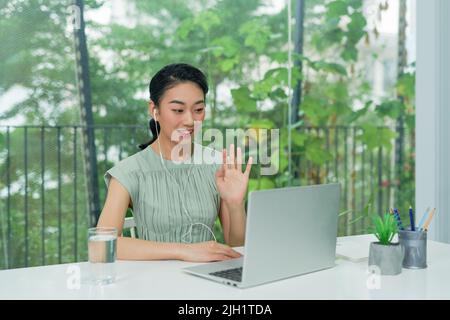 Femme jeune femme d'affaires regardant la webcam et parlant lors d'une conférence téléphonique sur un ordinateur portable. Banque D'Images