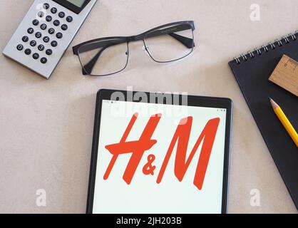 Sur cette illustration, le logo H & M Hennes & Mauritz AB ou H&M Group apparaît sur une tablette. Banque D'Images