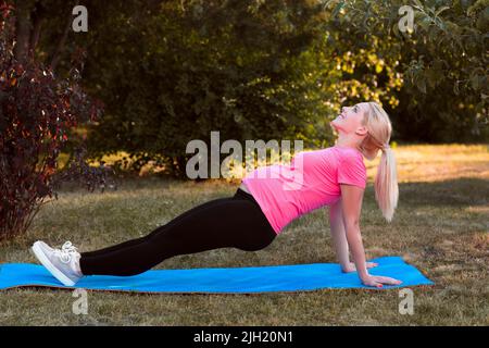 Jeune enceinte s'étirant en plein air, fitness Banque D'Images