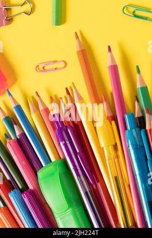 Imaginez différents articles de bureau et ustensiles en plastique, crayons, crayons sur fond jaune Banque D'Images