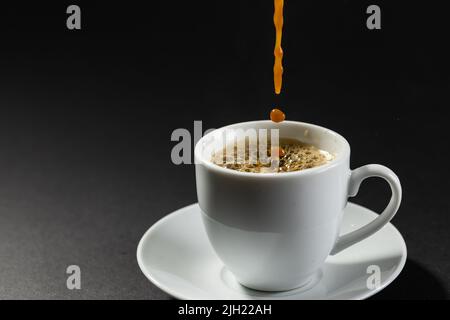 Image d'une tasse de café blanc chaud noir sur fond noir Banque D'Images