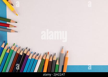 Image de crayons colorés feuille de papier blanche sur fond bleu Banque D'Images