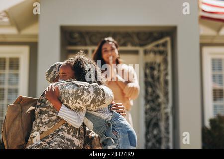 Militaire disant Au revoir à sa famille avant de partir pour la guerre. Un militaire américain embrassant sa fille. Un soldat patriotique qui laisse sa famille à Banque D'Images