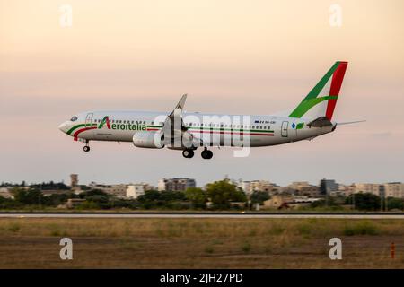 Aeroitalia Boeing 737-85F (REG: 9h-CRI) commençant des vols réguliers pour l'été, arrivant après le coucher du soleil. Banque D'Images