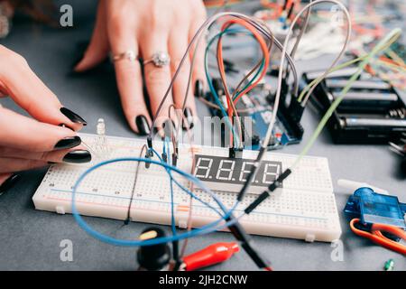 Femme ingénieur connectant la conduite à la carte d'expérimentation Banque D'Images