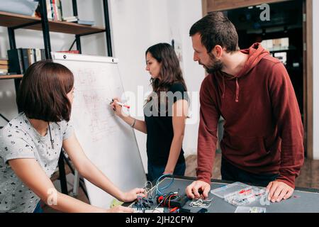 Schéma de câblage sur tableau blanc, travail d'équipe Banque D'Images